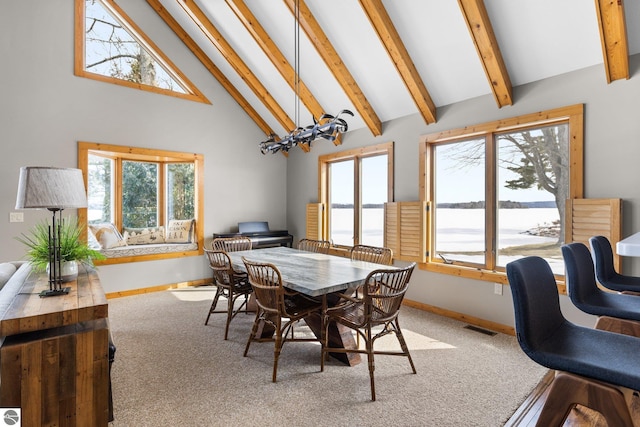 carpeted dining area featuring baseboards, visible vents, high vaulted ceiling, an inviting chandelier, and beamed ceiling