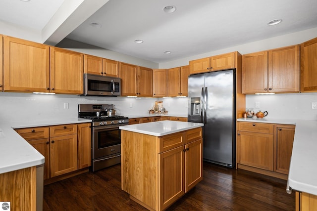 kitchen featuring dark wood-type flooring, appliances with stainless steel finishes, a center island, and light countertops