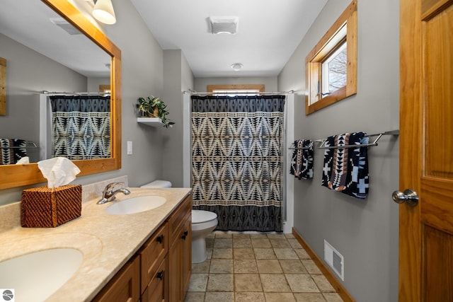 full bath with double vanity, visible vents, toilet, and a sink