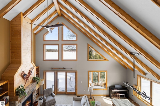 living room featuring beamed ceiling, carpet flooring, a healthy amount of sunlight, and high vaulted ceiling