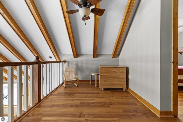 stairway with lofted ceiling with beams, wood finished floors, baseboards, and ceiling fan