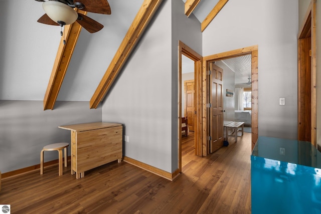 hall featuring baseboards, dark wood finished floors, and vaulted ceiling with beams