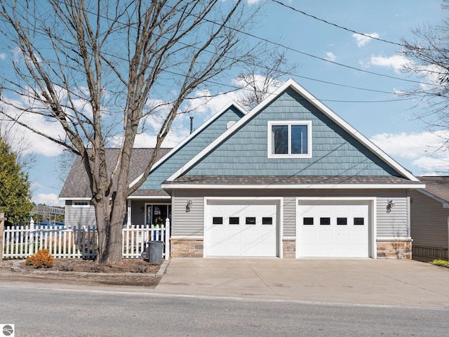 craftsman house with roof with shingles, driveway, stone siding, fence, and a garage