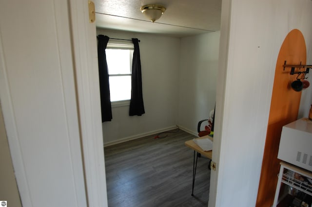 interior space featuring wood finished floors and baseboards