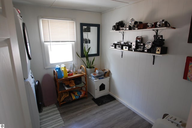 washroom with wood finished floors and stacked washer and clothes dryer