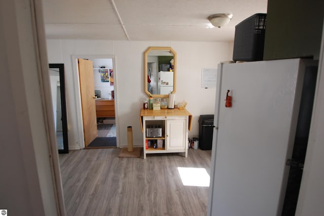 kitchen featuring wood finished floors and freestanding refrigerator