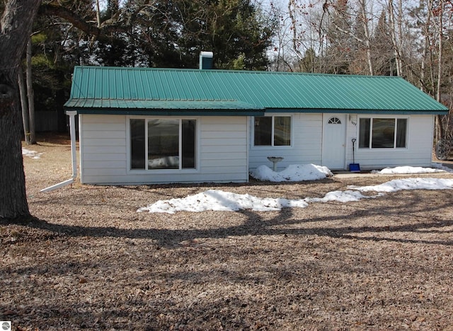 view of front facade with metal roof and a chimney