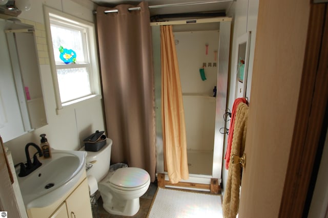 full bathroom with vanity, a shower stall, and toilet