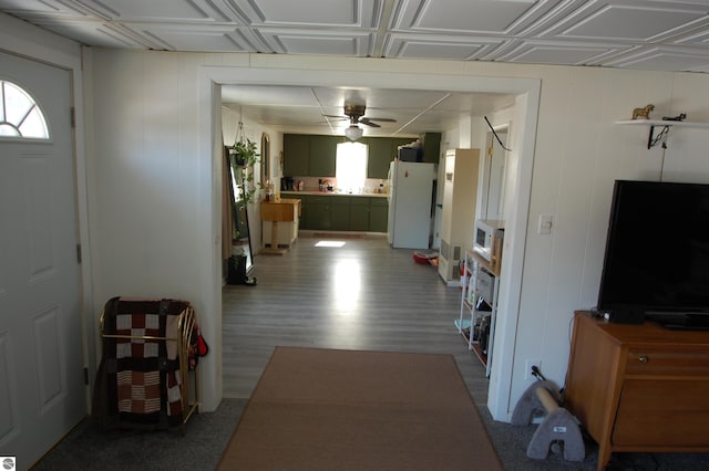 corridor with wood finished floors and an ornate ceiling