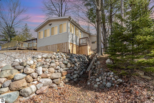 view of home's exterior featuring stairs and a wooden deck