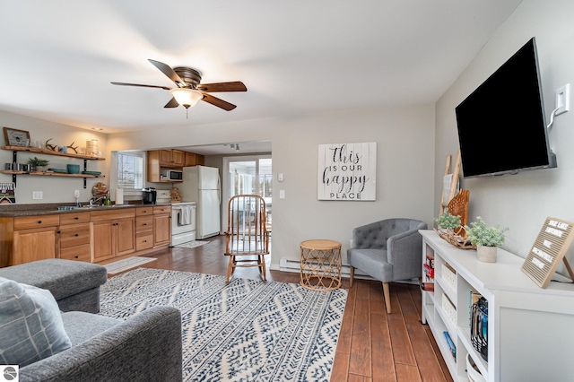 living area with baseboards, dark wood-style flooring, and ceiling fan