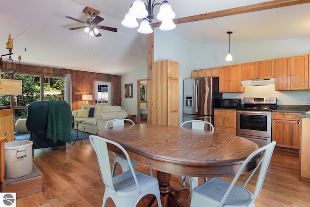 dining area featuring light wood-type flooring, wooden walls, high vaulted ceiling, and ceiling fan with notable chandelier