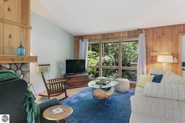 living room with vaulted ceiling, wood walls, and a wall mounted air conditioner