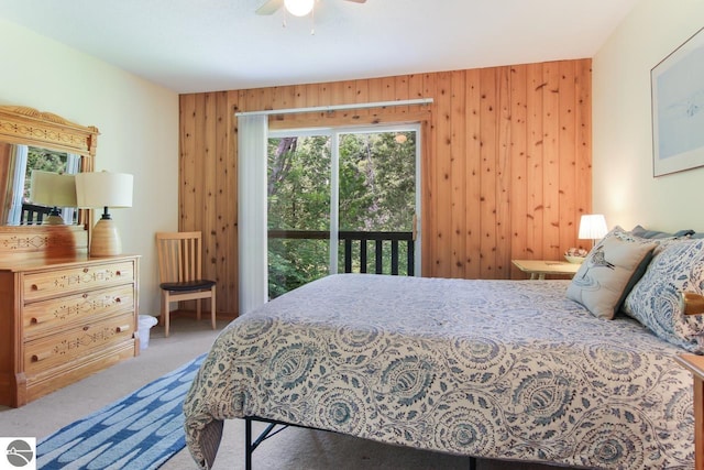 bedroom with wood walls, carpet, and ceiling fan