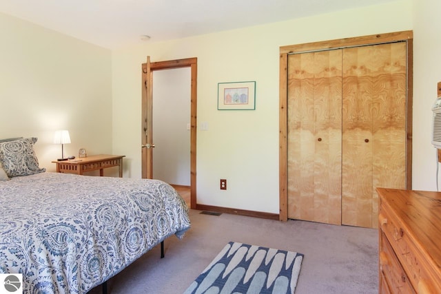 bedroom with a closet, baseboards, carpet, and visible vents