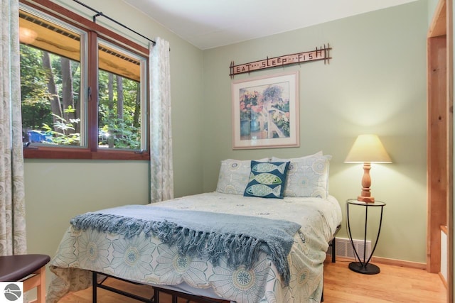 bedroom featuring visible vents, baseboards, and wood finished floors