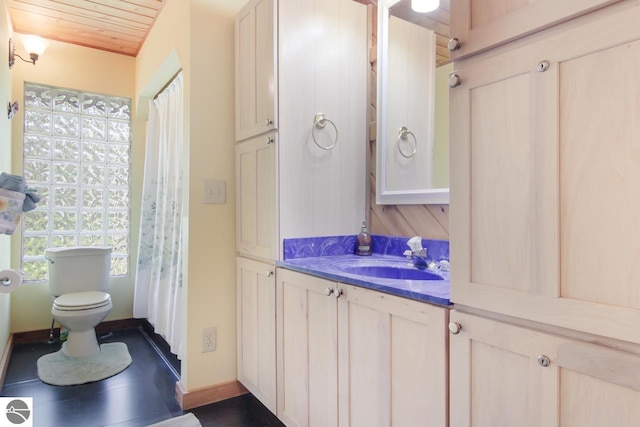 bathroom featuring vanity, toilet, wood ceiling, and baseboards