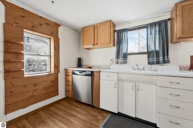 kitchen with light countertops, light wood-type flooring, baseboards, and stainless steel dishwasher