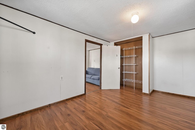 unfurnished bedroom featuring wood finished floors and a textured ceiling