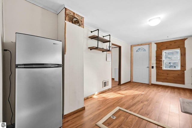 kitchen featuring visible vents, light wood finished floors, and freestanding refrigerator