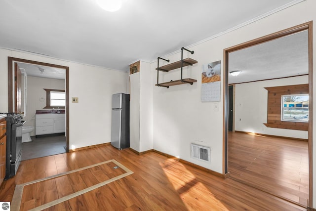 interior space with visible vents, a sink, baseboards, and wood finished floors