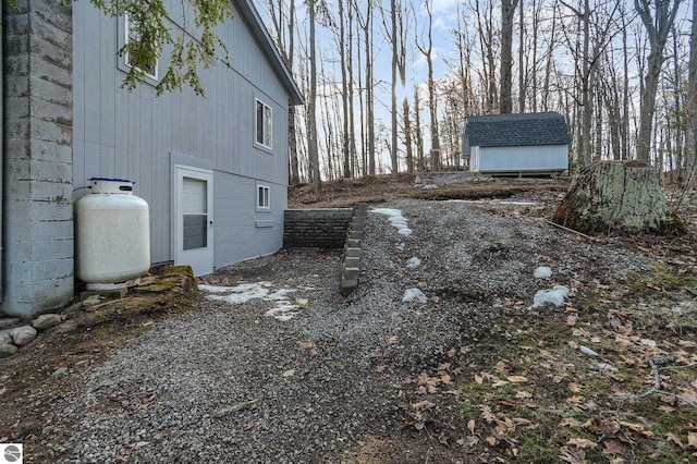 view of side of home featuring a storage shed and an outbuilding