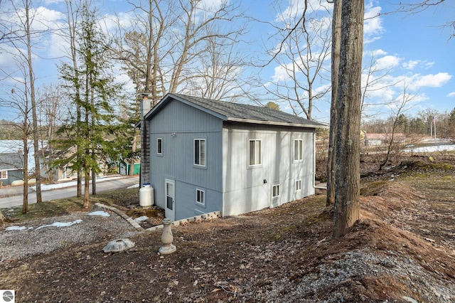 view of side of home featuring an outdoor structure and a chimney