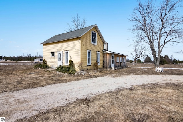 view of side of property featuring dirt driveway