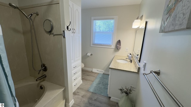 bathroom featuring visible vents, baseboards, toilet, wood finished floors, and vanity