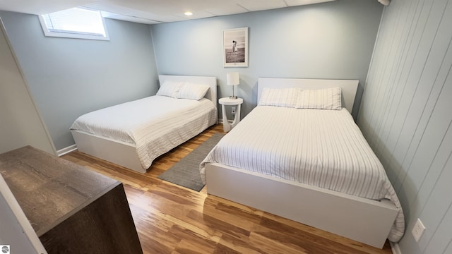 bedroom featuring wooden walls and wood finished floors