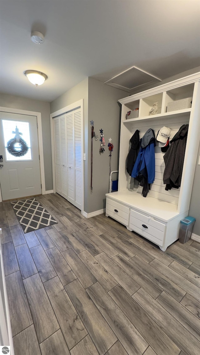 mudroom with attic access, baseboards, and wood tiled floor