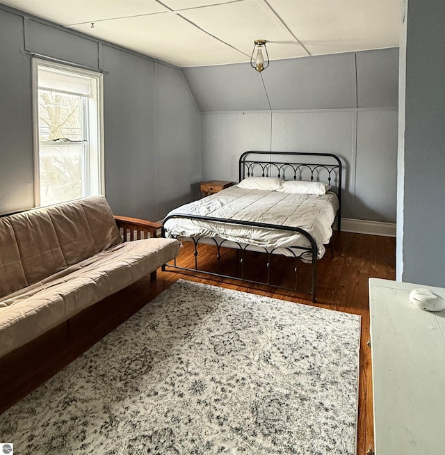 bedroom featuring vaulted ceiling, baseboards, and wood finished floors