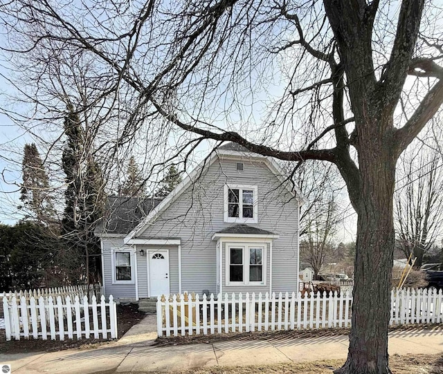 view of front of house featuring a fenced front yard and a shingled roof