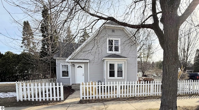 view of front facade featuring a fenced front yard and roof with shingles