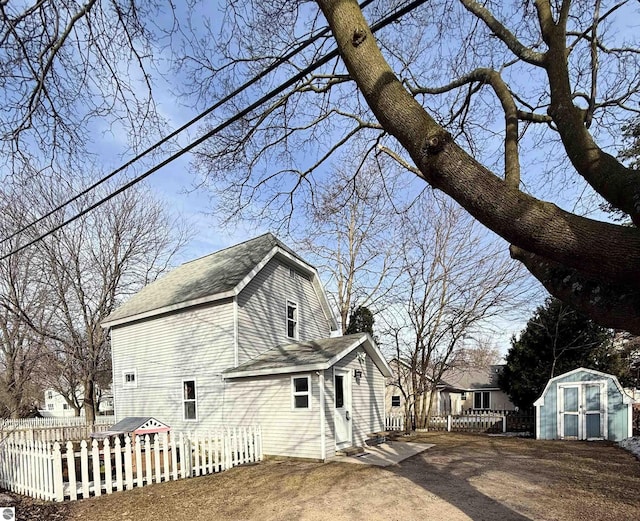 view of home's exterior with a storage shed, an outdoor structure, and fence