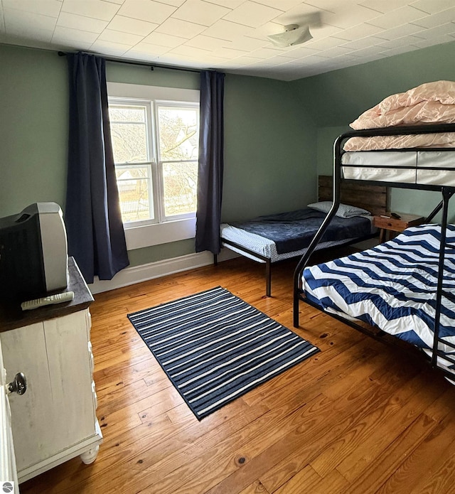 bedroom with wood finished floors and baseboards