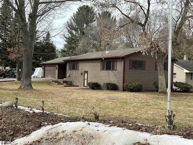 single story home featuring a front lawn and a garage