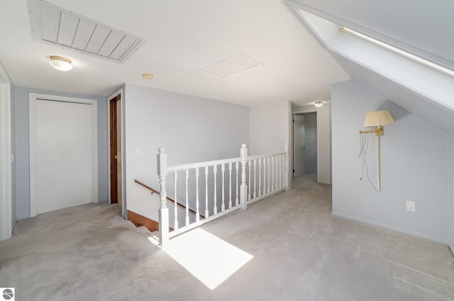 additional living space featuring baseboards, carpet flooring, attic access, and visible vents