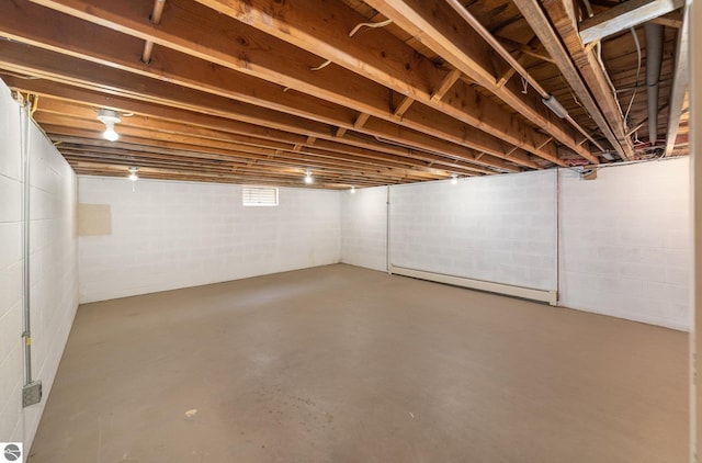 unfinished basement featuring a baseboard heating unit