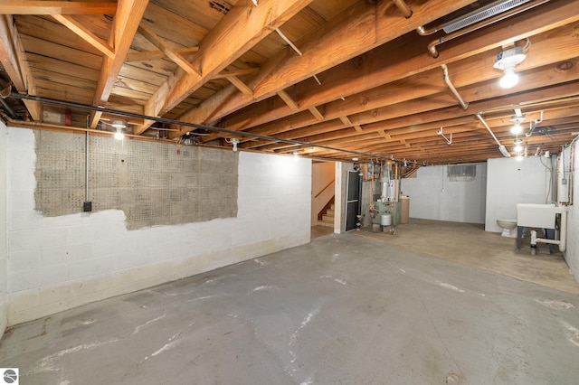 unfinished basement featuring stairs and a sink