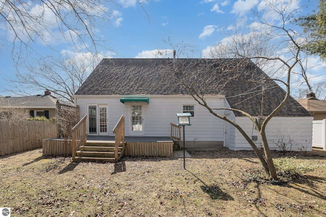 rear view of house with a deck and fence