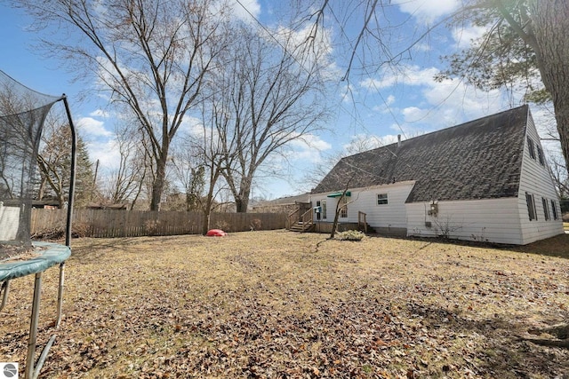 view of yard with a trampoline and fence