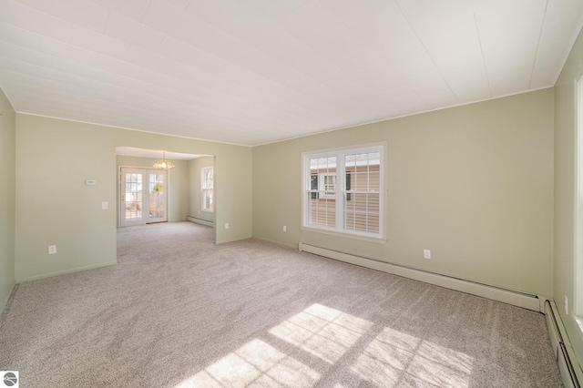 carpeted empty room featuring a notable chandelier, a baseboard heating unit, baseboards, and a baseboard radiator