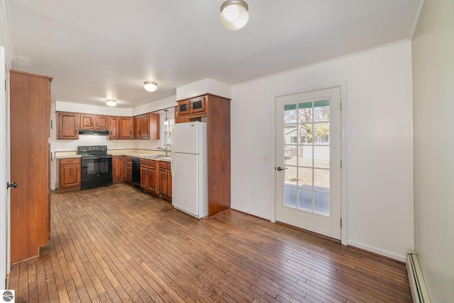 kitchen with a baseboard radiator, brown cabinets, black appliances, and dark wood finished floors