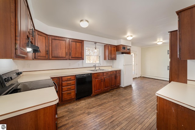 kitchen featuring dark wood-type flooring, black appliances, a sink, light countertops, and a baseboard radiator