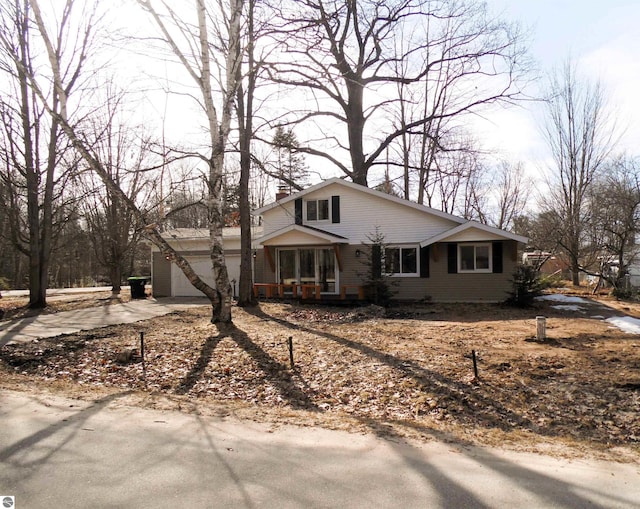 4177 Seminole St, Gladwin, MI 48624 - view of front of home featuring concrete driveway, an attached garage, and a chimney