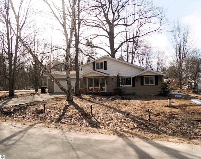 view of front of property with a porch, a garage, driveway, and a chimney