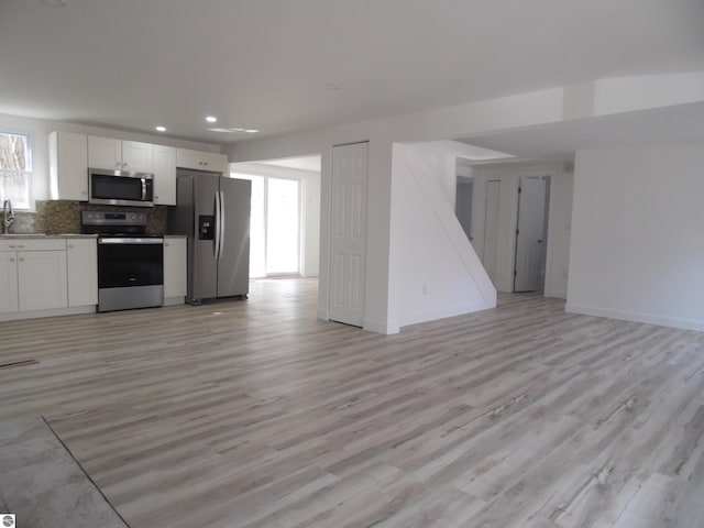 4177 Seminole St, Gladwin, MI 48624 - kitchen with stainless steel appliances, open floor plan, a sink, white cabinetry, and recessed lighting
