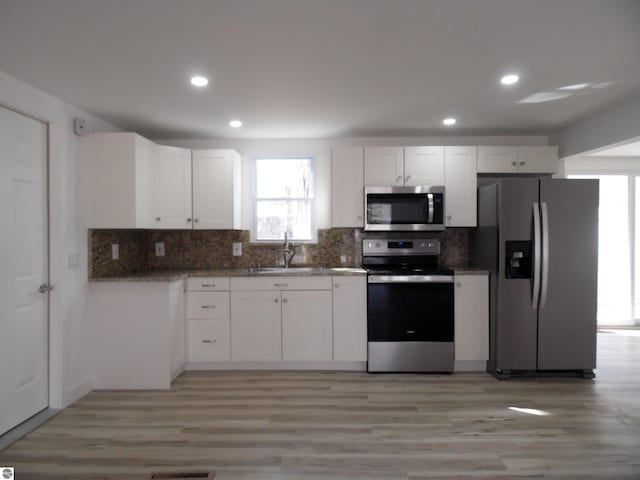 4177 Seminole St, Gladwin, MI 48624 - kitchen featuring appliances with stainless steel finishes, a sink, backsplash, healthy amount of natural light, and recessed lighting