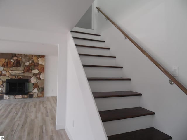 4177 Seminole St, Gladwin, MI 48624 - stairway featuring wood finished floors and a stone fireplace